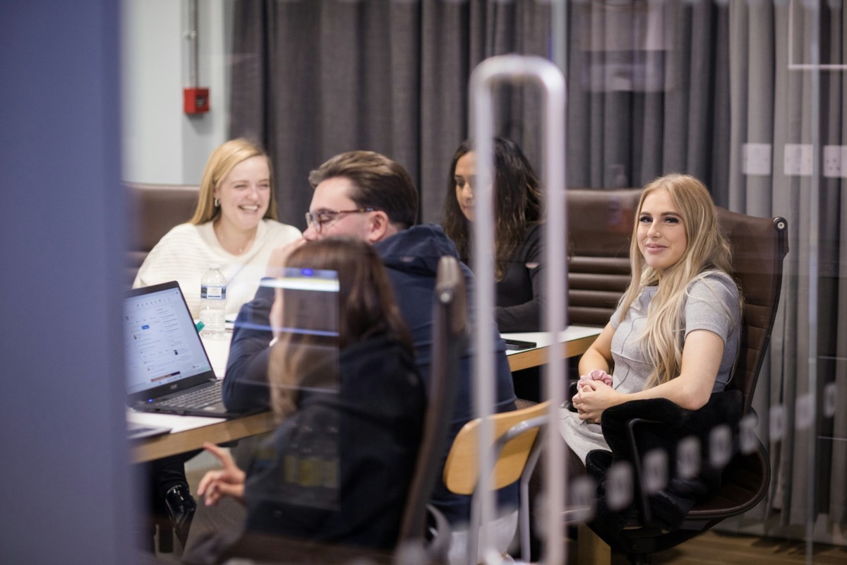 Colleagues meeting around laptops in a London office